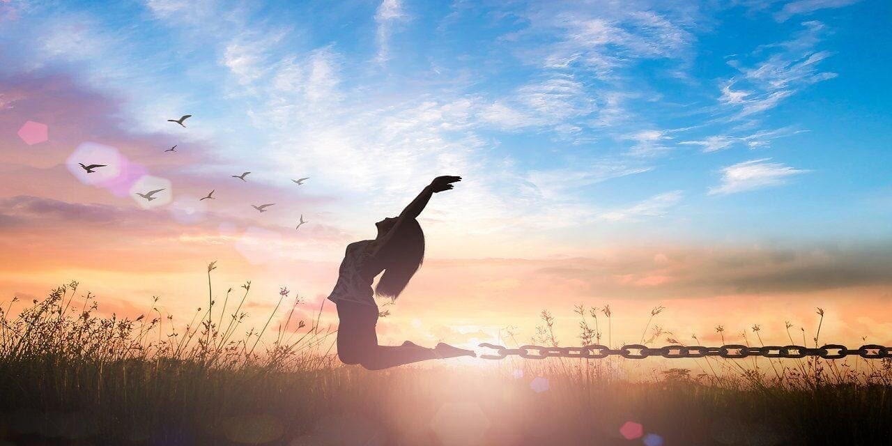 silhouette of woman celebrating by jumping in field presumably because of healing after trauma