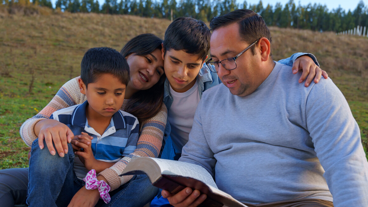 A family reading Spanish Christian resources like the Bible together