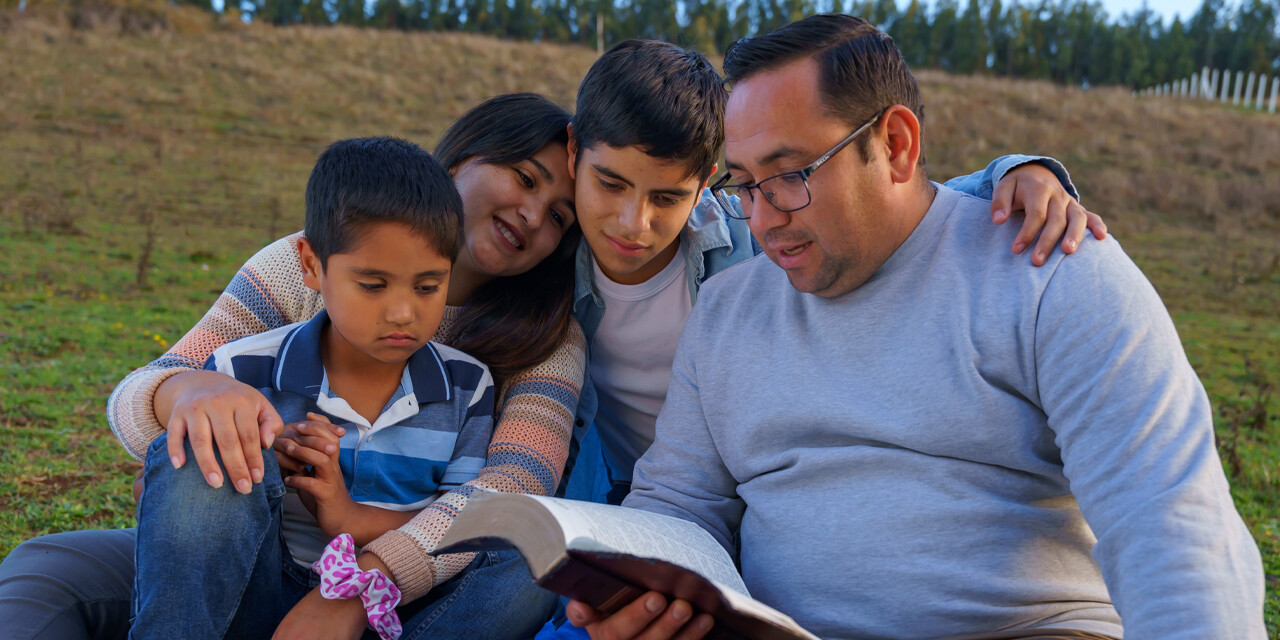 A family reading Spanish Christian resources like the Bible together