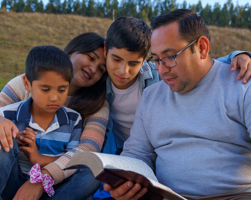 A family reading Spanish Christian resources like the Bible together