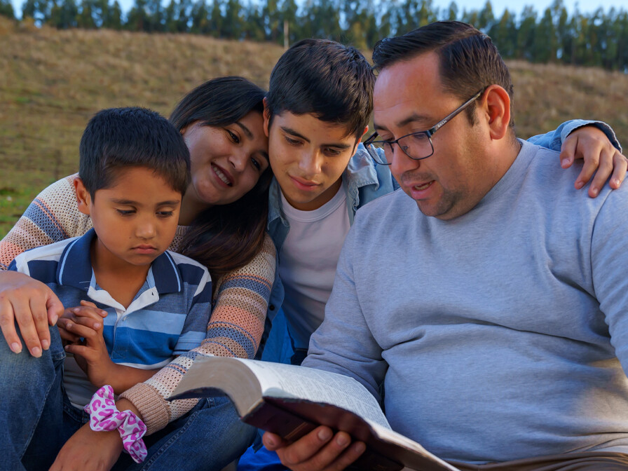 A family reading Spanish Christian resources like the Bible together
