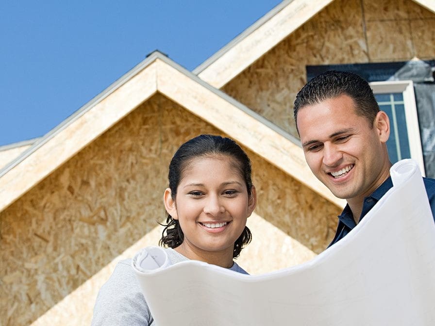 A couple is looking at plans for a house and how to build a stronger marriage