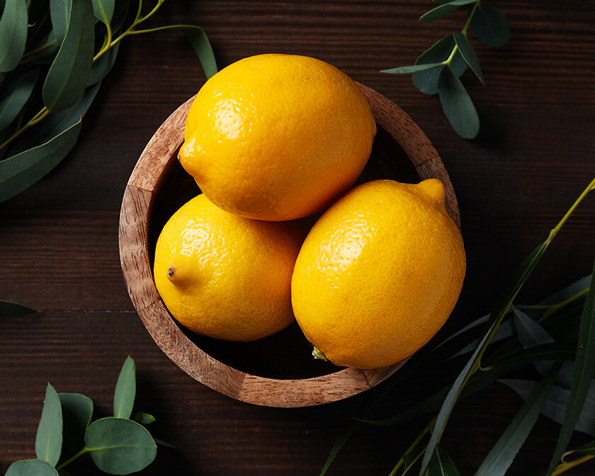 Bright yellow lemons in a wooden dish, showing something good and happy that's blossomed from a seed.