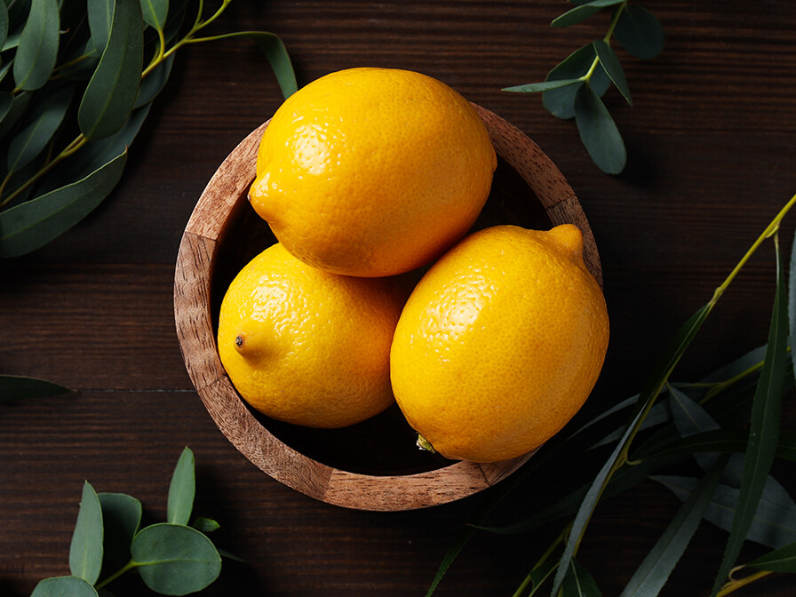 Bright yellow lemons in a wooden dish, showing something good and happy that's blossomed from a seed.