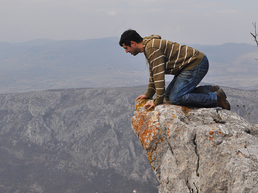 Man looking over a cliff, wondering how to be free from fear