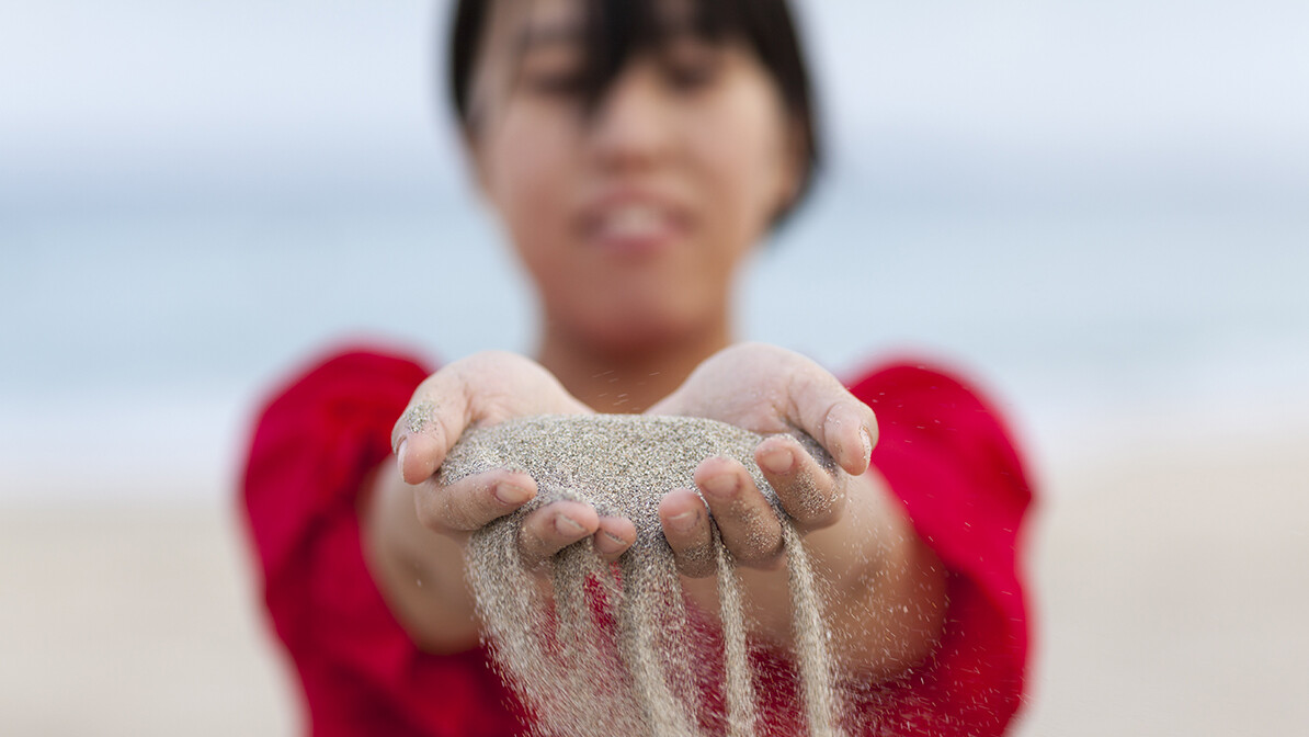 sand sifting through woman's hands, letting go and trusting God
