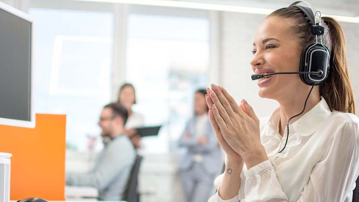 Smiling Woman Answering the Phone at a Call Center Similar to the Inspiration Prayer Center