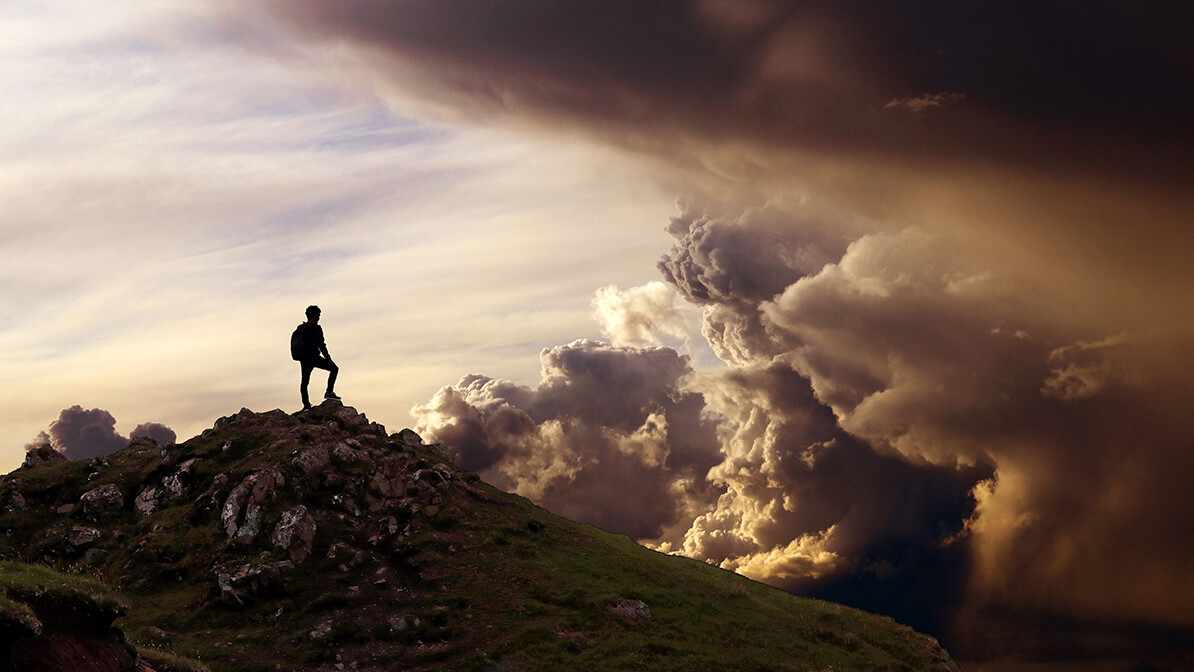 man standing on mountain looking at dark clouds; 3 biblical keys to spiritual power