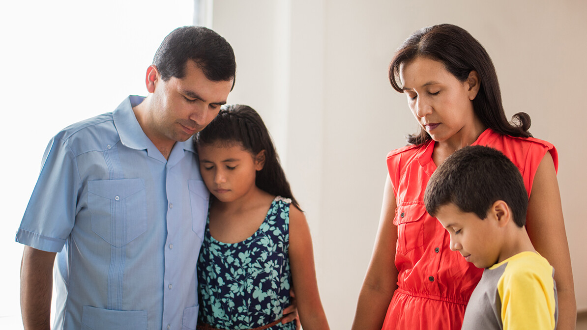 sad Hispanic family that is struggling and praying together, pray for your family