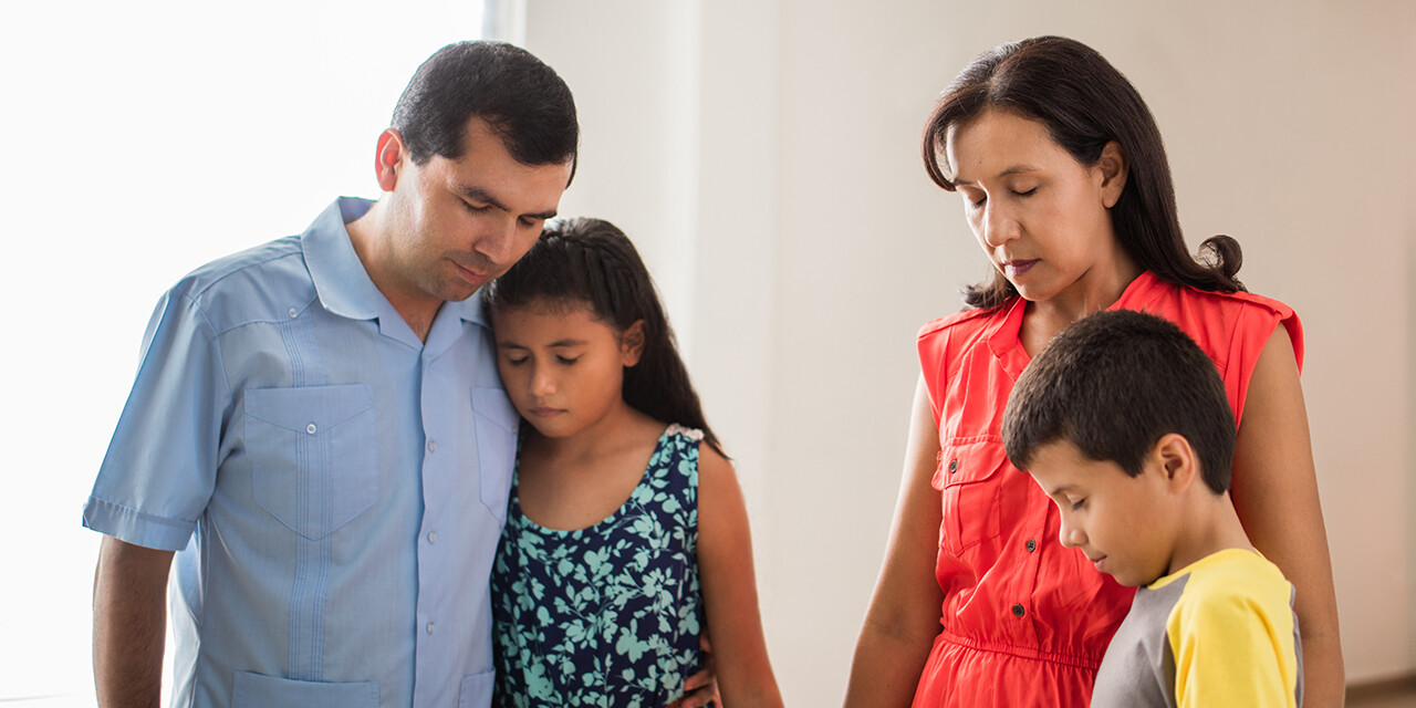 sad Hispanic family that is struggling and praying together, pray for your family