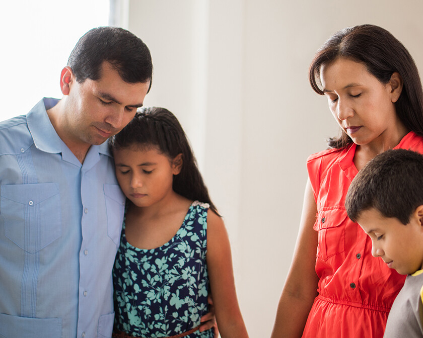 sad Hispanic family that is struggling and praying together, pray for your family