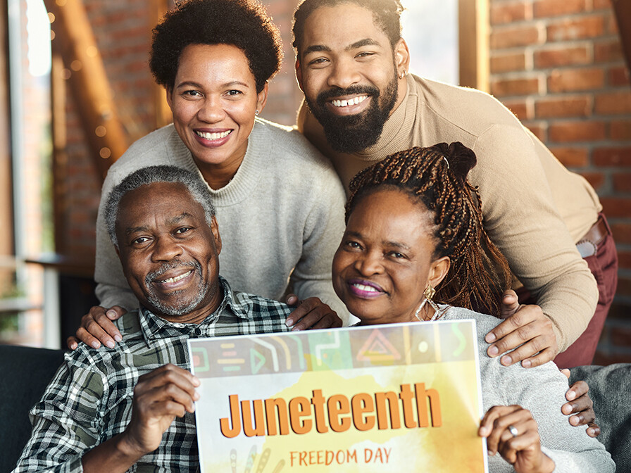Juneteenth, family of four holding Juneteenth sign