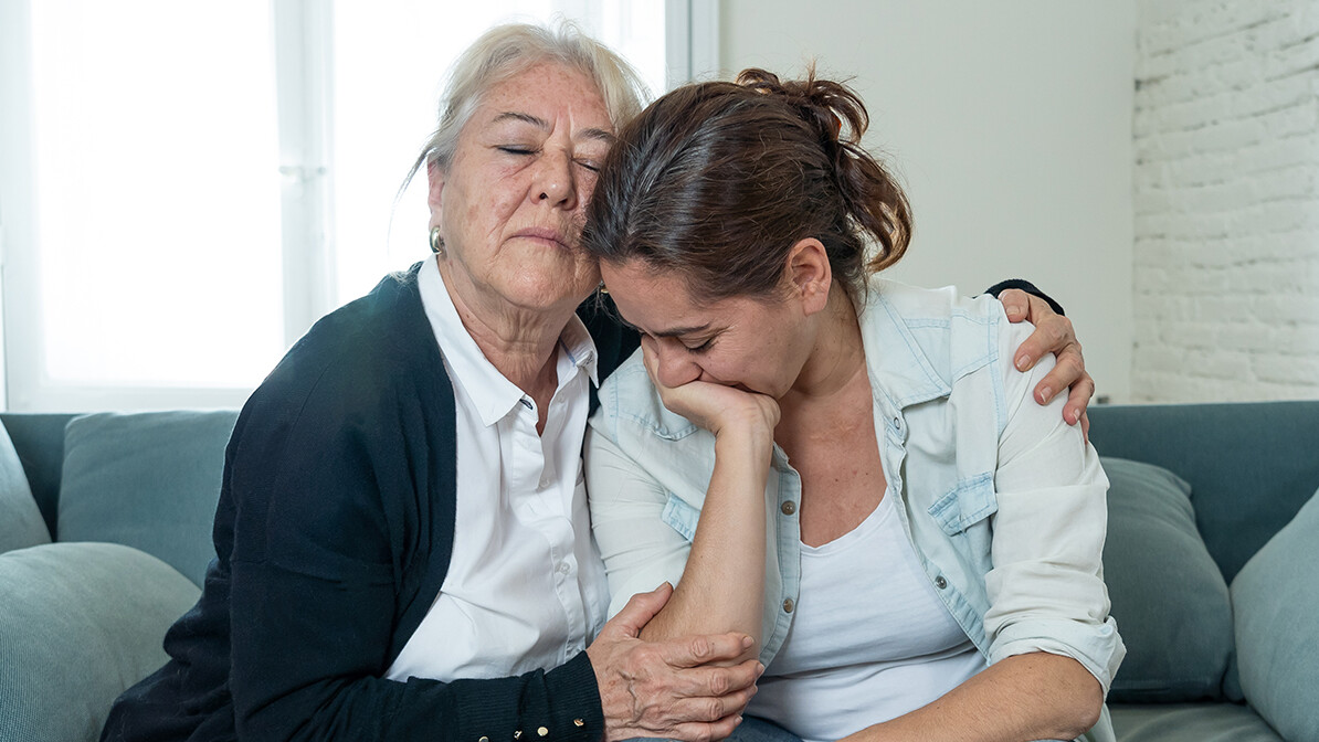 Grandmother hugging her daughter to comfort her during a moment of sadness.