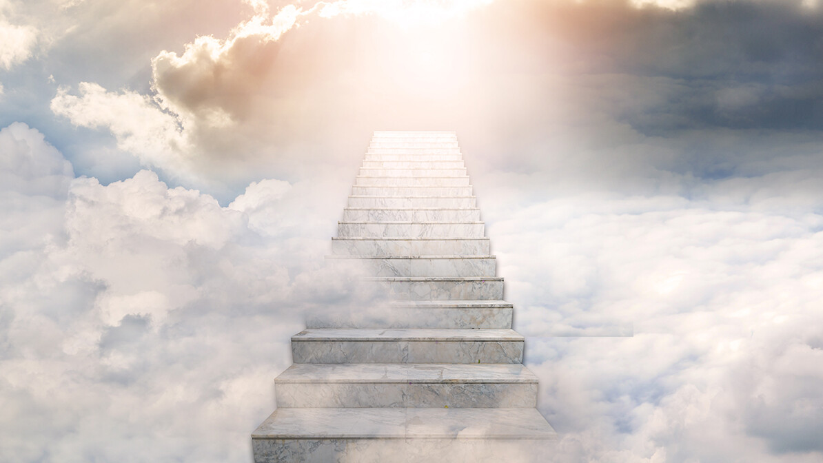 Concrete stairs leading toward sunlight breaking through the clouds.