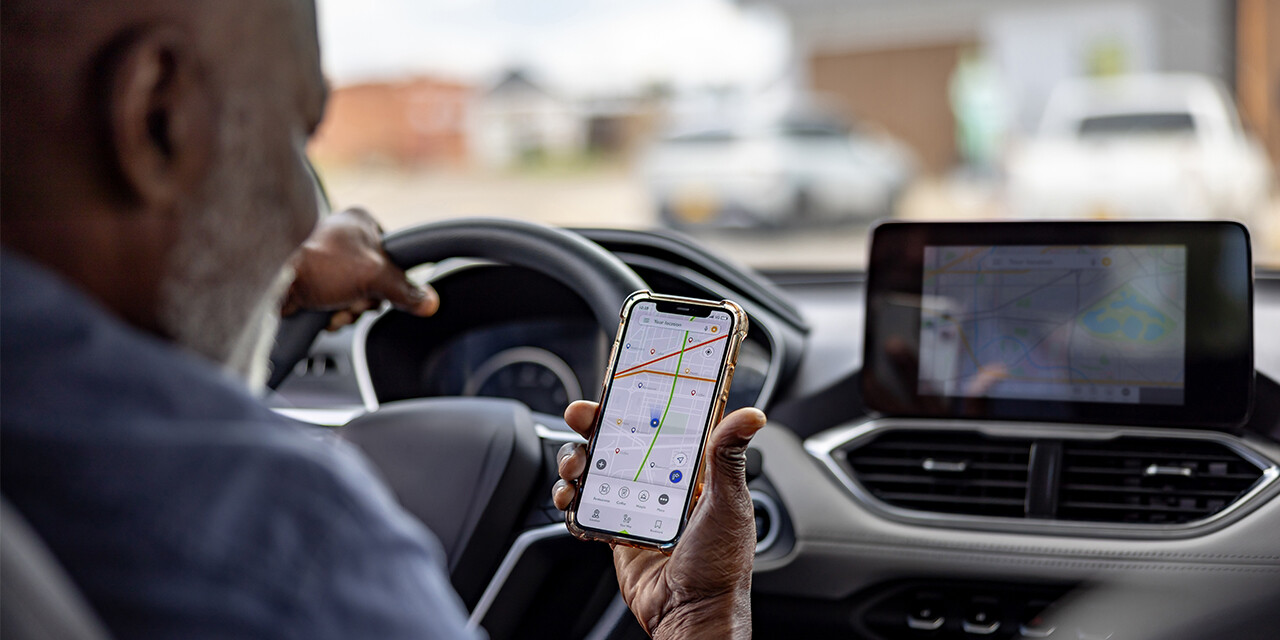 Man using GPS navigation while driving a car.