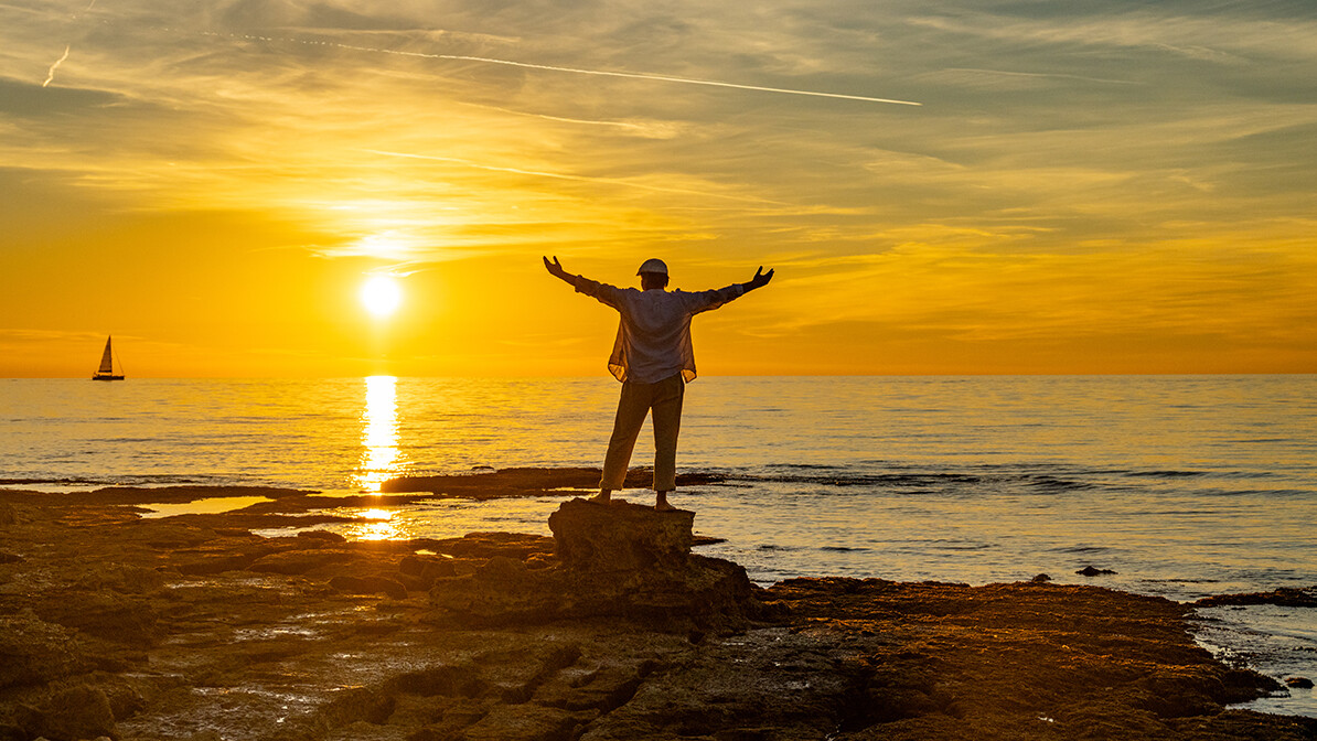 man praising God at sunset with arms raised; how to be content